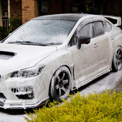 White car covered in snow and ice on a driveway